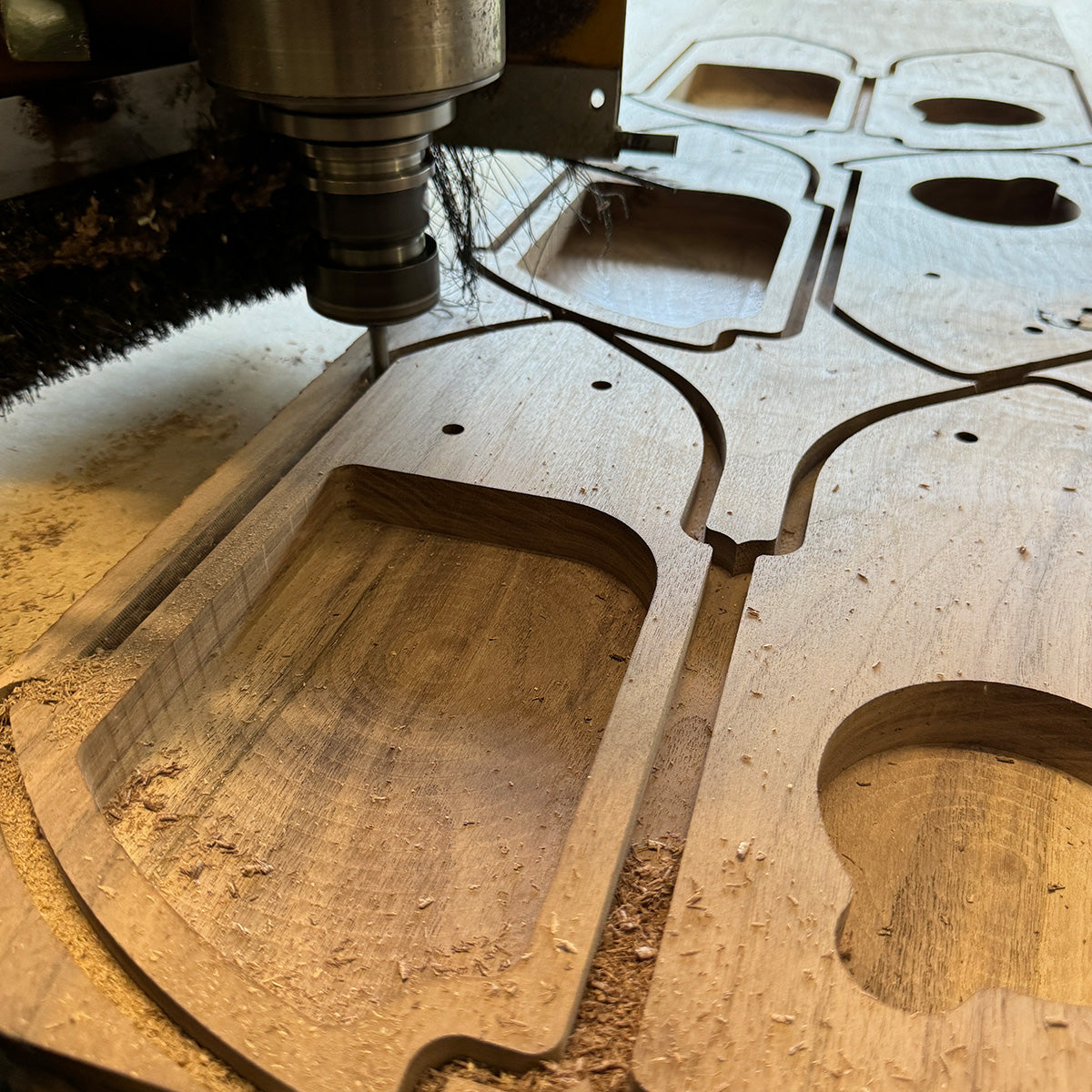 CNC machine cutting a wooden panel with precise shapes